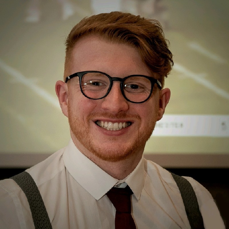 Aaron, brand and product launch consultant at Weavers & Co, smiling in formal attire — expert in Lancashire digital campaigns and storytelling.